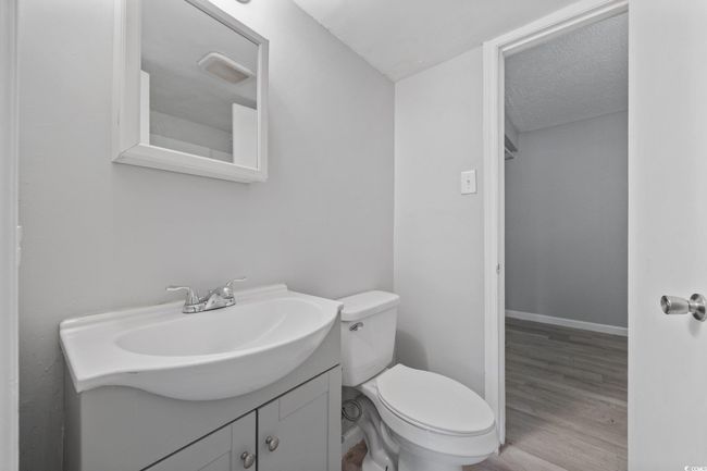 Half bath featuring vanity, toilet, wood finished floors, and baseboards | Image 10