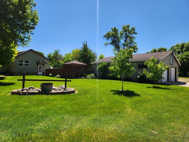 The front/west yard shows home and detached garage. | Image 26