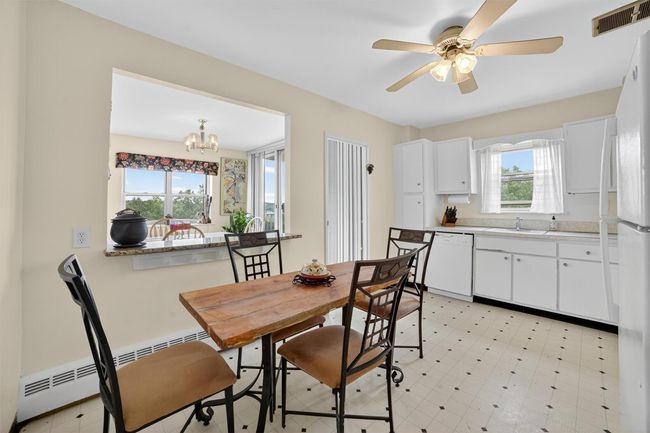 Dining space featuring plenty of natural light, a baseboard radiator, ceiling fan, and a chandelier | Image 17