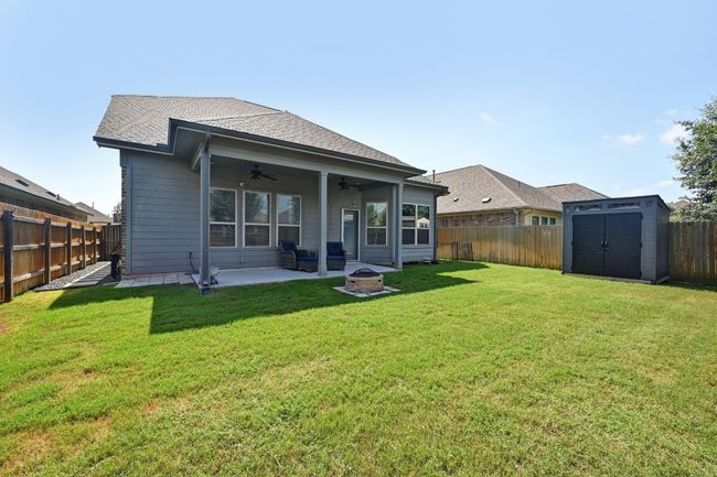 Back of property with ceiling fan, an outdoor fire pit, a fenced backyard, and a patio area | Image 29