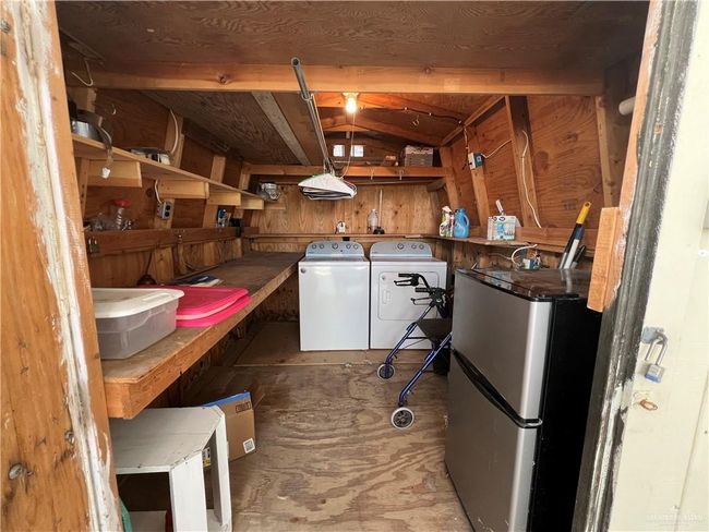 Basement featuring stainless steel fridge and washer and clothes dryer | Image 11
