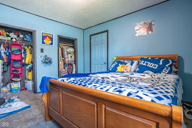 bedroom with carpet floors, a textured ceiling, and a closet | Image 18