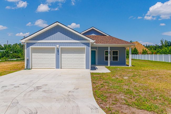 Single story home with driveway, covered porch, a shingled roof, and a garage | Image 30