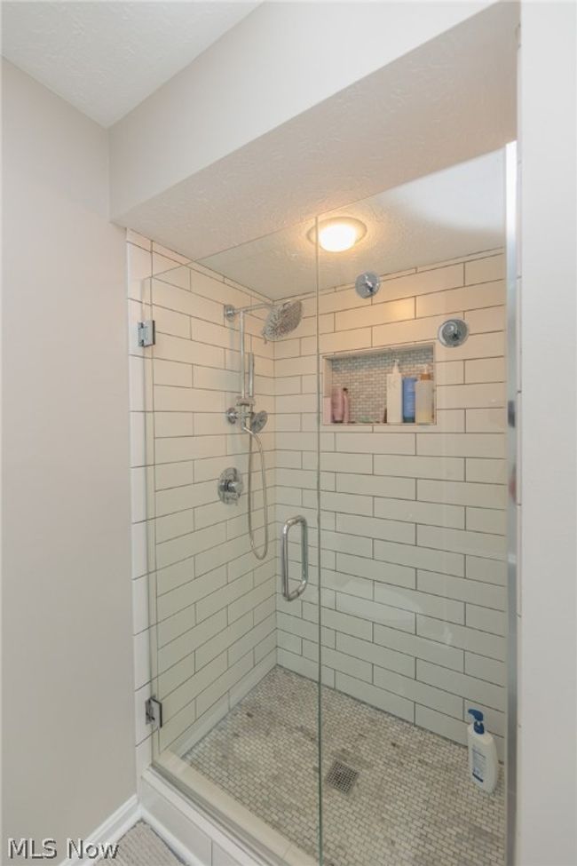 Bathroom featuring a shower with shower door and a textured ceiling | Image 28