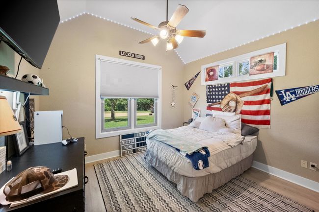 Bedroom featuring lofted ceiling, wood finished floors, baseboards, and ceiling fan | Image 20