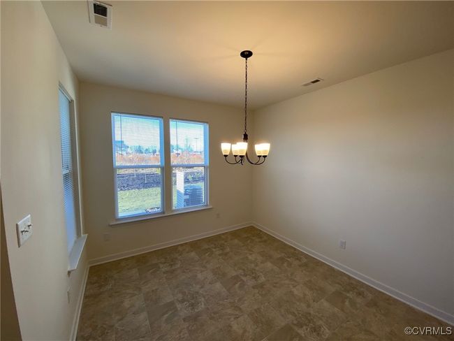 Spare room with a chandelier and baseboards | Image 5