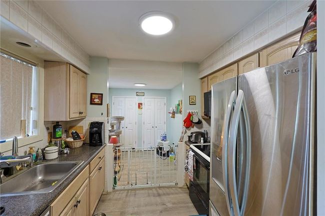 Kitchen with view to bonus room, with two pantries and door to garage | Image 5