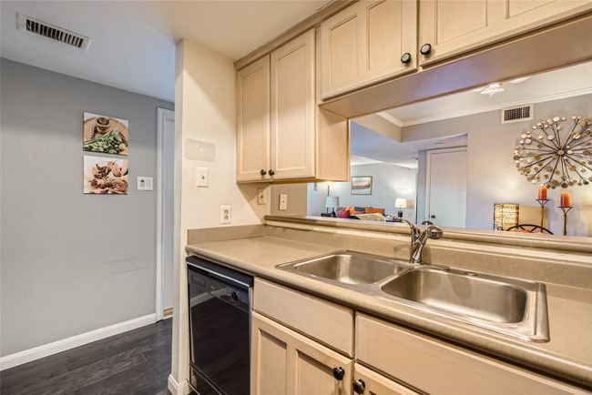 Kitchen with dishwasher, dark wood-style floors, a sink, light countertops, and baseboards | Image 9
