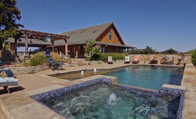 View of pool featuring an in ground hot tub, a pergola, a patio, and pool water feature | Image 1