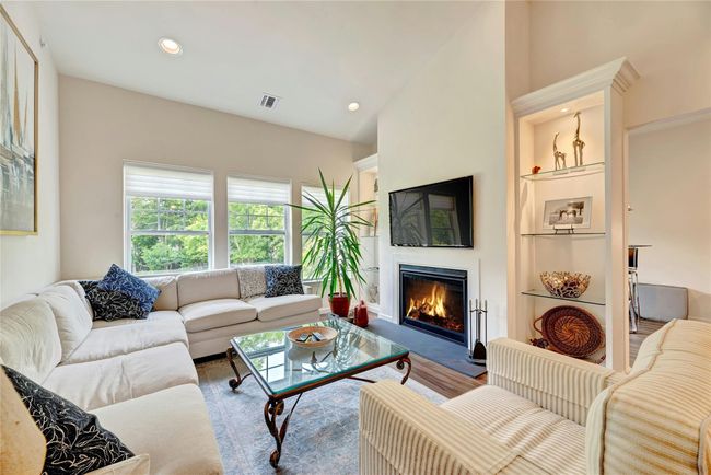 Living room featuring a glass covered fireplace and recessed lighting | Image 5