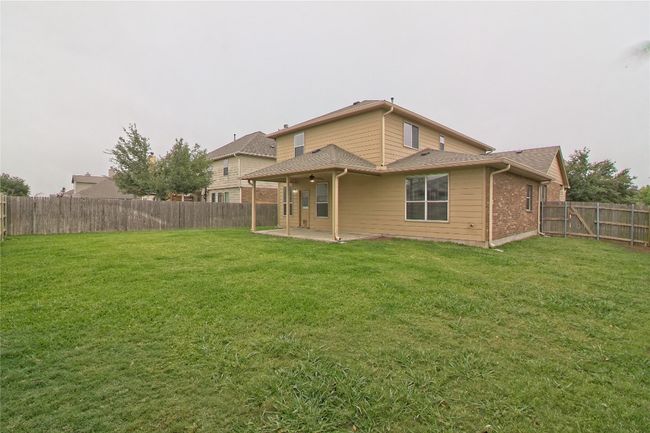 Rear view of house with a patio area, a fenced backyard, and brick siding | Image 30