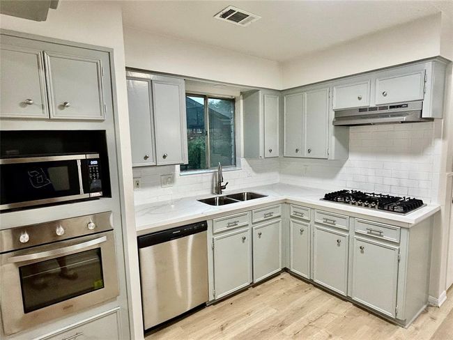 Updated kitchen with Granite countertops, light tile and updated cabinets | Image 11