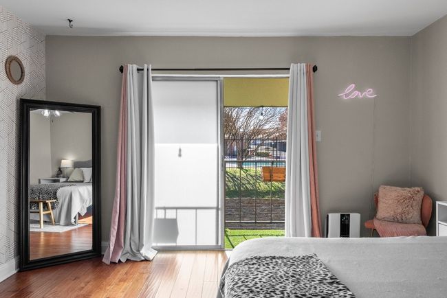 Primary bedroom featuring ceiling fan, wood-style flooring, a spacious walk-in closet and access to the balcony with a view to the pool | Image 32