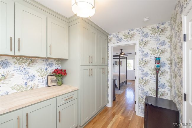Laundry room with wallpapered walls, wood counters, light wood-style floors, and ceiling fan | Image 15