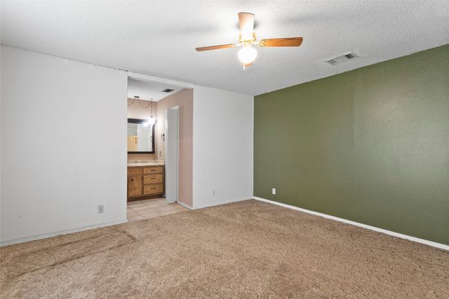 Unfurnished room featuring light colored carpet, ceiling fan, and a textured ceiling | Image 24