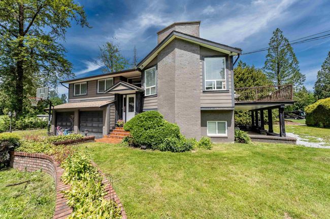 View of front of property with brick siding, an attached garage, and a front lawn | Image 33