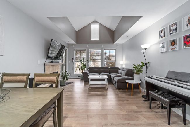 Living room with a tile fireplace, high vaulted ceiling, light wood-type flooring, and baseboards | Image 12