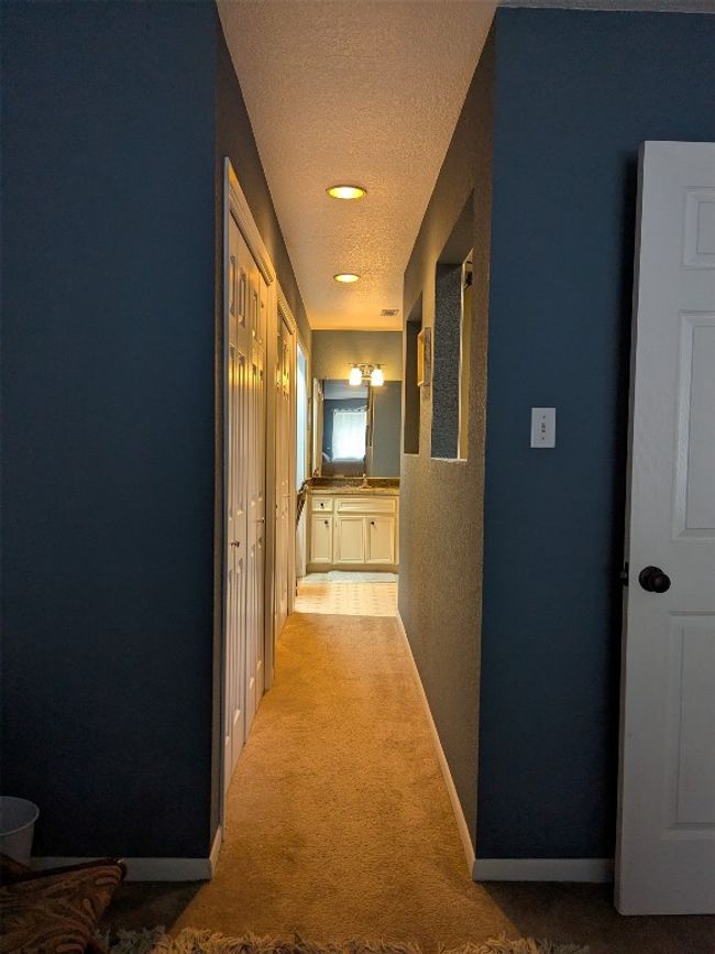 Hallway with a textured ceiling, light carpet, and a textured wall | Image 21
