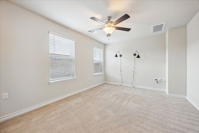 Spare room featuring light colored carpet, a ceiling fan, visible vents, and baseboards | Image 15