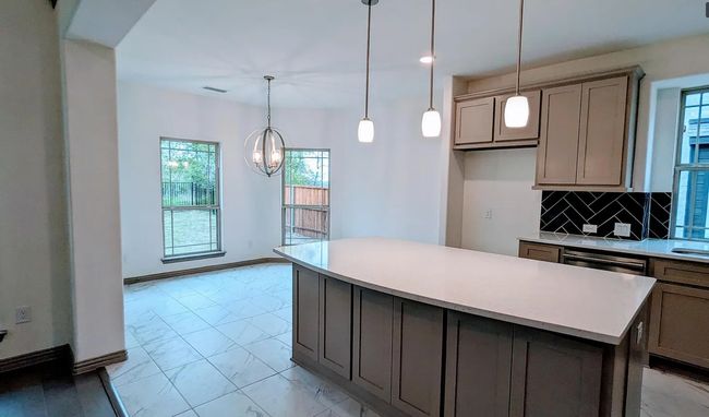 Kitchen featuring marble finish floor, a healthy amount of sunlight, gray cabinetry, and a chandelier | Image 11