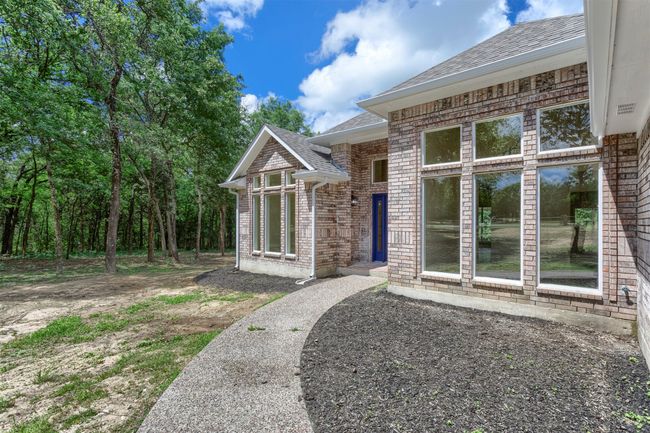 Doorway to property featuring a shingled roof and brick siding | Image 4