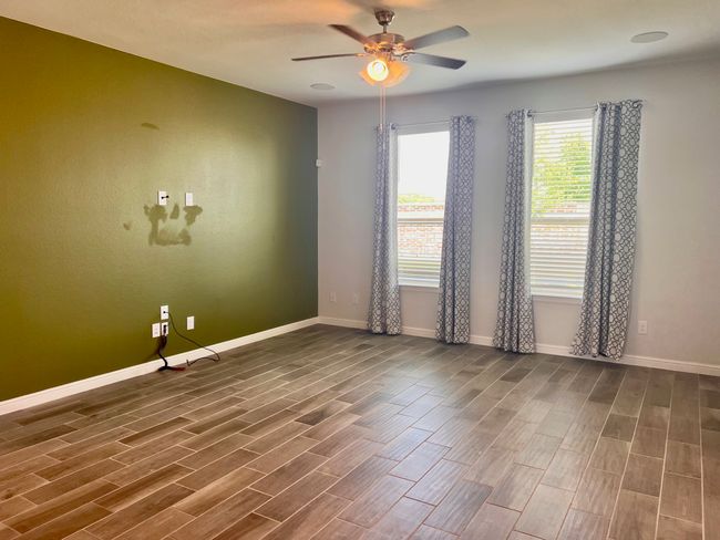 Empty room with wood finished floors and a ceiling fan | Image 12