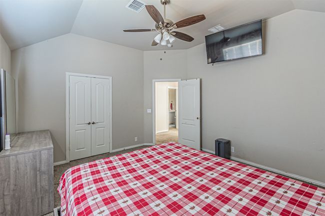 Bedroom with vaulted ceiling, a closet, carpet flooring, and ceiling fan | Image 38