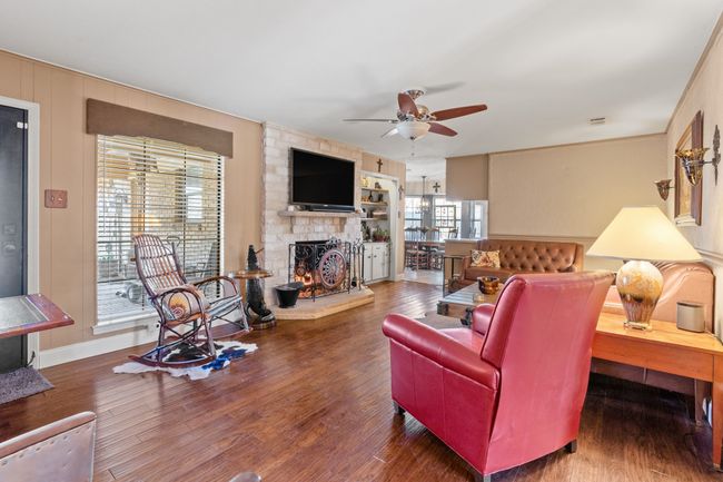 DEN featuring dark hardwood / wood-style flooring, ceiling fan, and a fireplace | Image 9