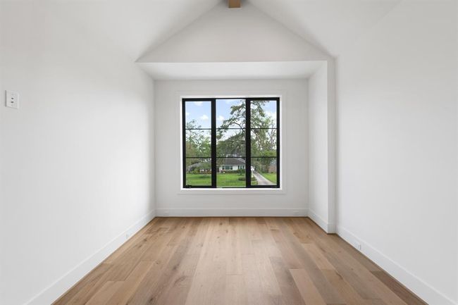 One of five thoughtfully designed secondary bedrooms, this upstairs suite features generous proportions, wide-plank white oak flooring, and abundant natural light. The ensuite bath continues the elevated aesthetic with designer tile, modern fixtures, and a seamless walk-in shower. | Image 31
