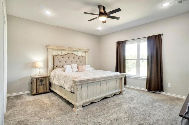 Bedroom featuring light colored carpet and ceiling fan | Image 22