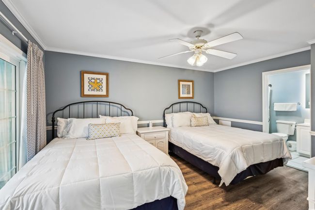 Bedroom with ornamental molding, wood finished floors, ceiling fan, and connected bathroom | Image 27