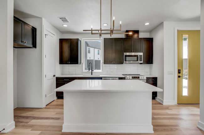 Kitchen featuring stainless steel appliances, a sink, light wood-style flooring, healthy amount of natural light, and recessed lighting | Image 7