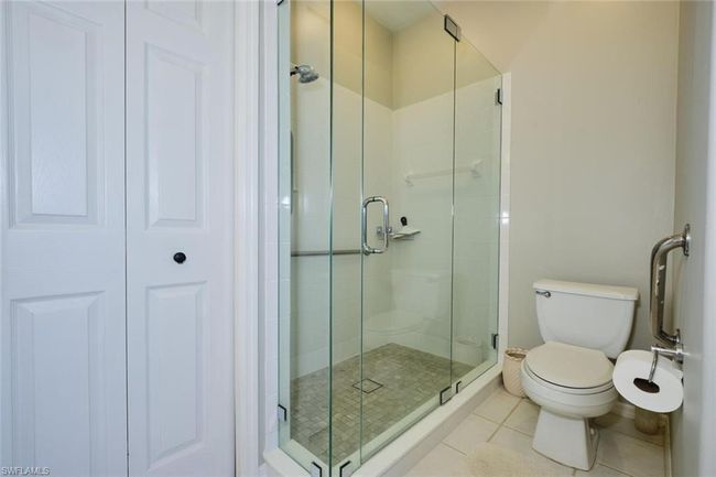 Bathroom featuring toilet, a shower with door, and tile patterned floors | Image 38