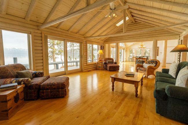 Sunroom featuring vaulted ceiling with skylight, ceiling fan with notable chandelier, and wood ceiling | Image 33