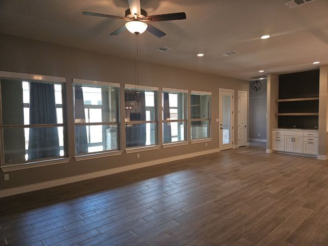 Unfurnished living room with ceiling fan, dark wood-style flooring, and recessed lighting | Image 5