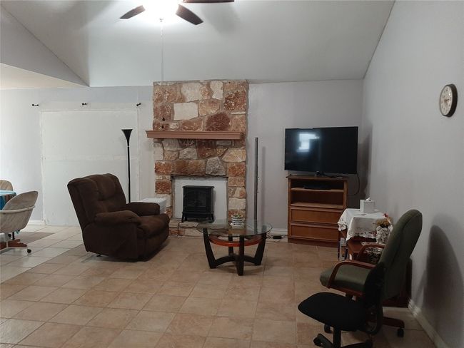 Living area with a ceiling fan and fireplace | Image 5