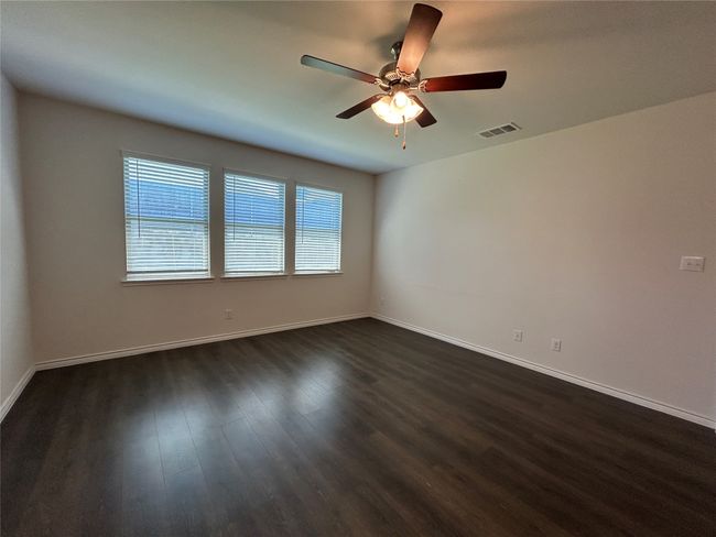 Unfurnished room featuring dark wood finished floors, a ceiling fan, and baseboards | Image 10