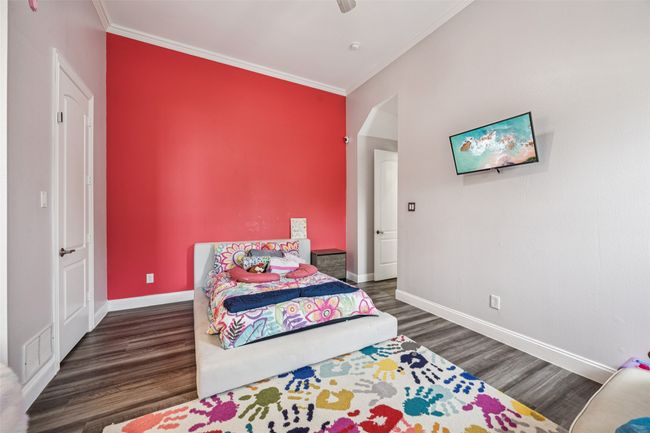 Bedroom with crown molding, wood finished floors, and a ceiling fan | Image 18