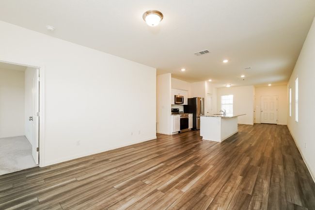 Unfurnished living room with dark wood-style floors and recessed lighting | Image 6