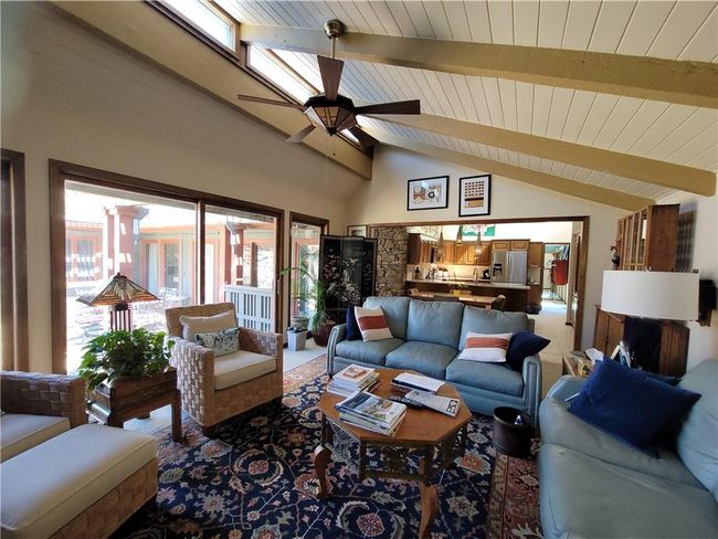 Living area with lofted ceiling with beams, ceiling fan, and wood ceiling | Image 19