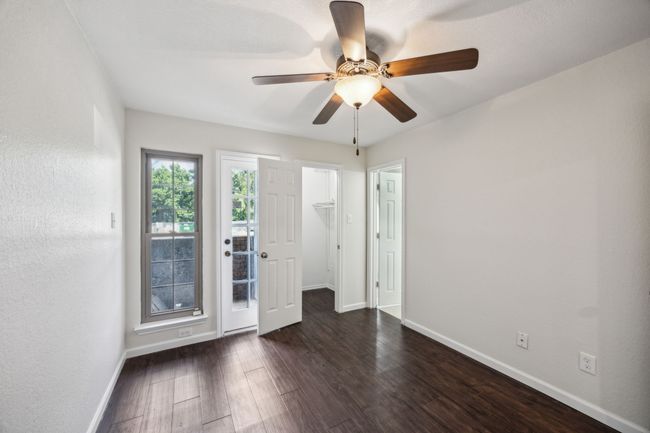 Spacious bedroom featuring baseboards, dark wood-type flooring, and a ceiling fan that opens to private patio | Image 18
