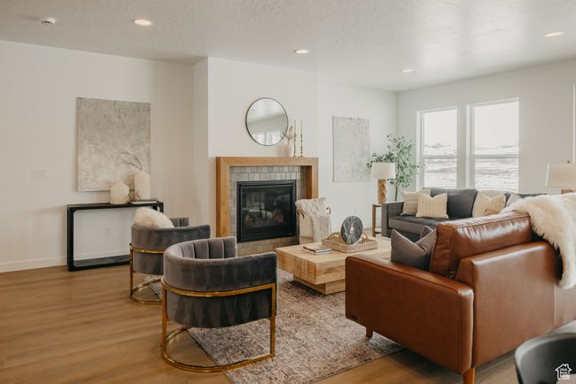 Living room with wood finished floors, a fireplace, recessed lighting, and baseboards | Image 9