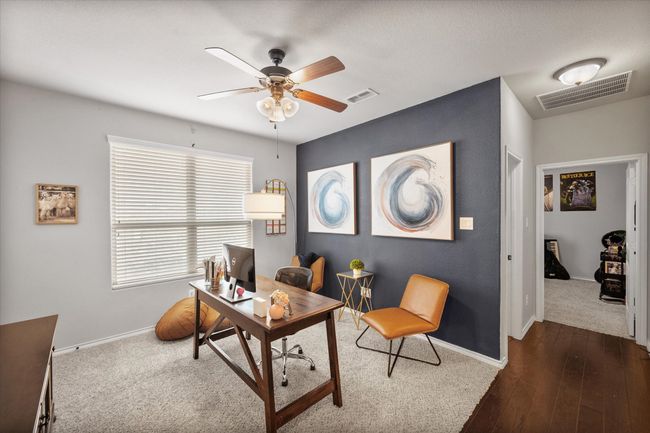 Office area with dark wood-style floors, baseboards, a ceiling fan, and visible vents | Image 11