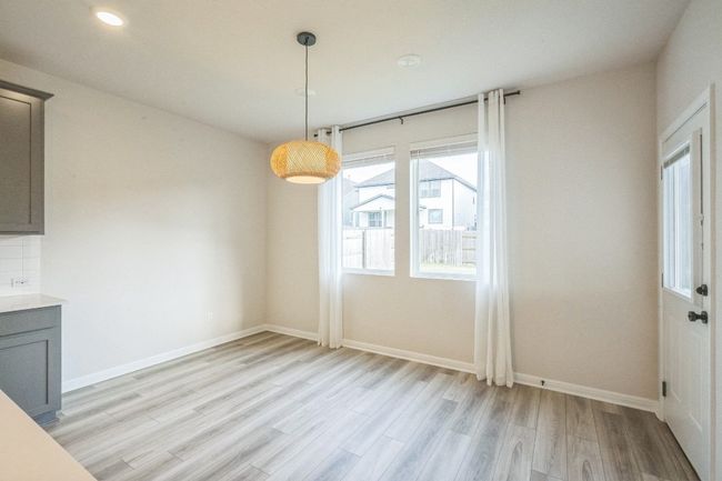 Unfurnished dining area with light wood-style flooring, baseboards, and recessed lighting | Image 11