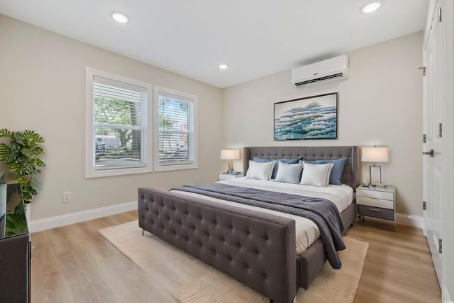 Bedroom featuring a wall mounted air conditioner, light wood-type flooring, baseboards, and recessed lighting | Image 28