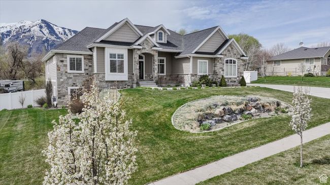 Craftsman-style house with stone siding, a front yard, fence, and a mountain view | Image 15