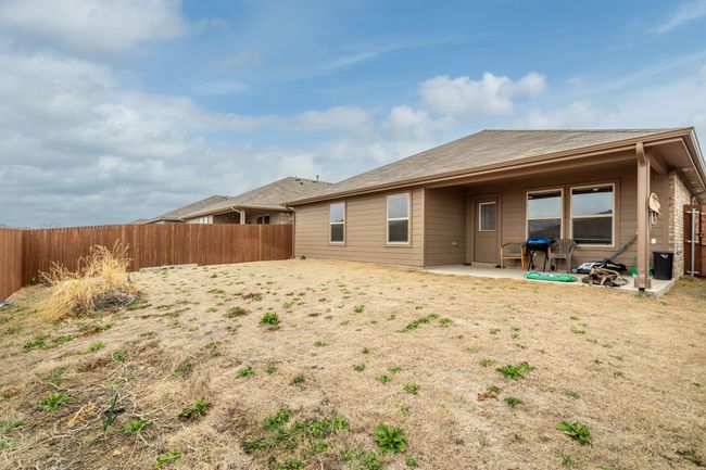 Rear view of house featuring a fenced backyard and a patio area | Image 26