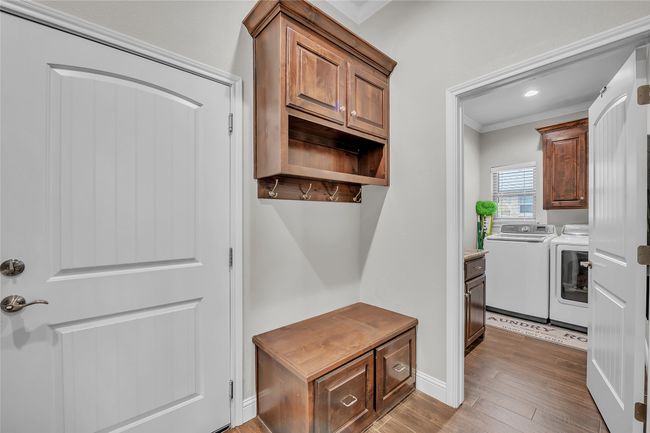 Mudroom with washer and clothes dryer, crown molding, wood finished floors, baseboards, and recessed lighting | Image 24