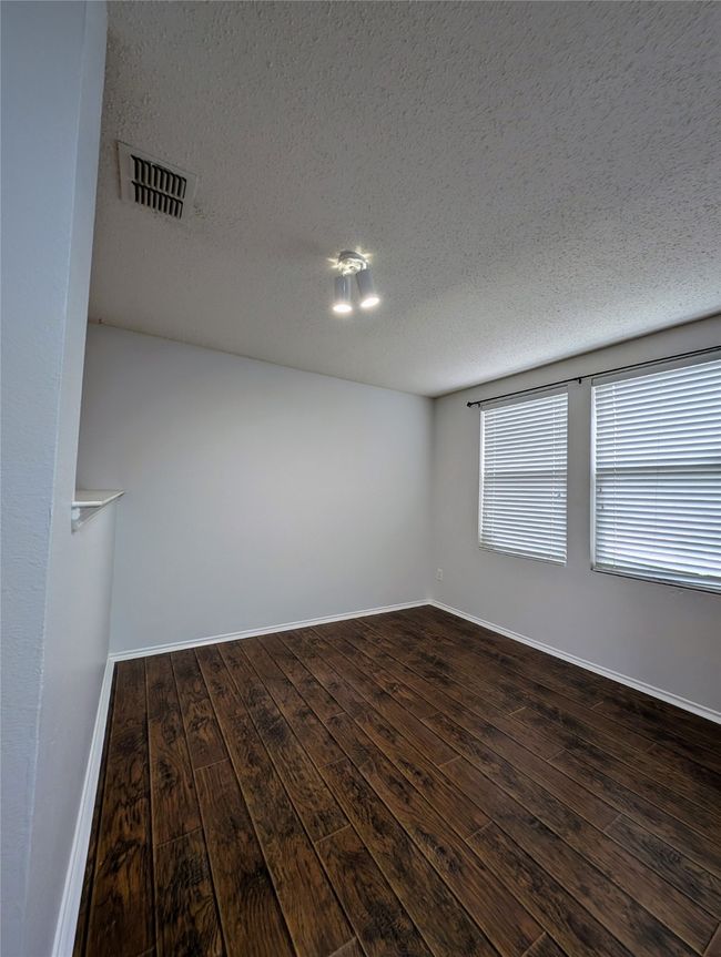 Unfurnished room with dark wood-style flooring, a textured ceiling, and baseboards | Image 10