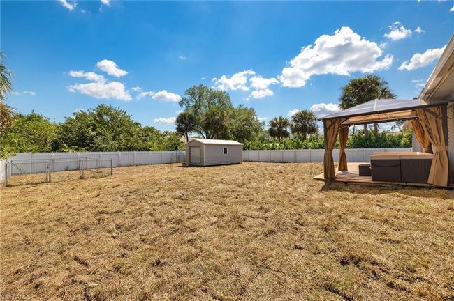 View of yard with an outdoor structure, a fenced backyard, a gazebo, and a storage shed | Image 24